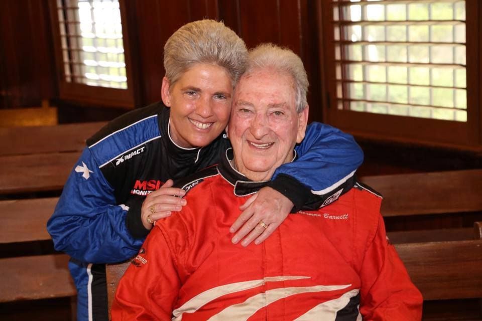 A couple embraces in their racing gear